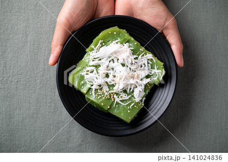 Traditional Thai dessert, pandan sweet pudding topped with coconut and toasted sesame seeds Traditional Thai dessert, pandan sweet pudding topped with coconut and toasted sesame seeds 141024836