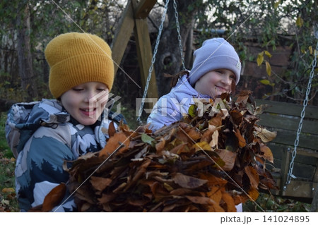 Young father, pre-teen daughter and son in warm autumn clothes spending quality time together among fallen leaves. Happy family enjoying the beauty of fall, playful moments and family life outdoors Young father, pre-teen daughter and son in warm autumn clothes spending quality time together among fallen leaves. Happy family enjoying the beauty of fall, playful moments and family life outdoors 141024895