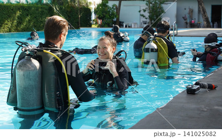Professional scuba diver instructs the novice how to use the equipment before dive 141025082