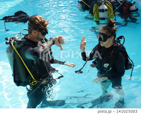 Professional scuba diver instructs the novice how to use the equipment before dive Professional scuba diver instructs the novice how to use the equipment before dive 141025083