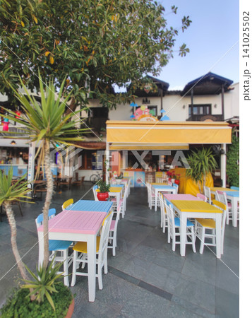 Empty outdoor cafe with colorful tables at dusk in Kas Turkey Empty outdoor cafe with colorful tables at dusk in Kas Turkey 141025502