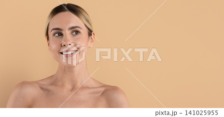 Smiling young woman with bare shoulders looking away, showcasing clear healthy skin Smiling young woman with bare shoulders looking away, showcasing clear healthy skin 141025955