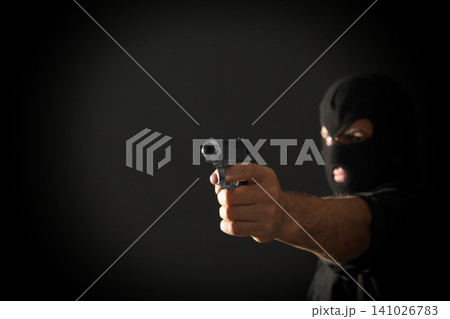 Professional killer on black background, focus on gun. Space for text Professional killer on black background, focus on gun. Space for text 141026783