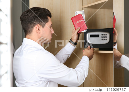 Man opening black steel safe with electronic lock at hotel 141026787