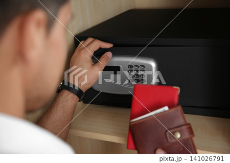 Man opening black steel safe with electronic lock at hotel, closeup 141026791