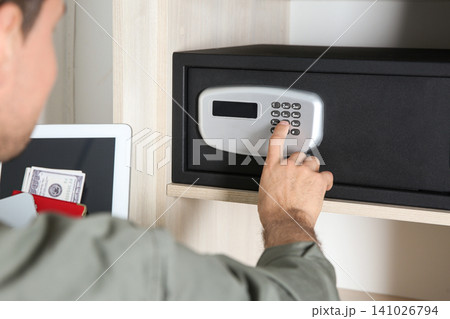 Man opening black steel safe with electronic lock at hotel, closeup 141026794