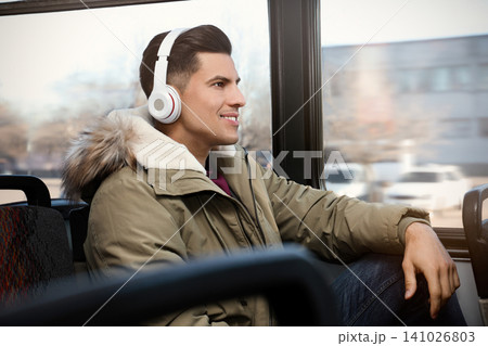 Man listening to audiobook in trolley bus Man listening to audiobook in trolley bus 141026803