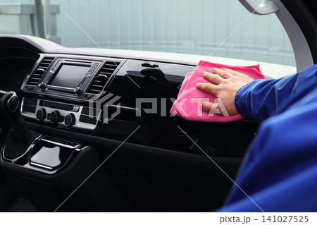 Car wash worker cleaning automobile interior, closeup Car wash worker cleaning automobile interior, closeup 141027525