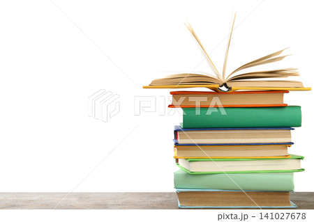 Stack of colorful books on wooden table against white background Stack of colorful books on wooden table against white background 141027678