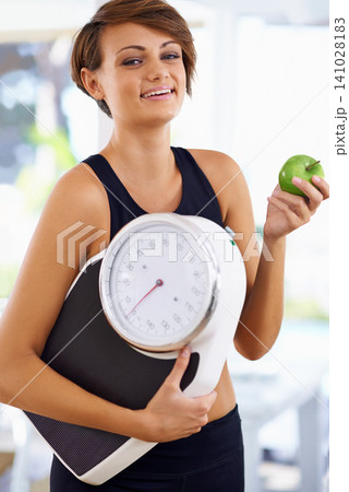 Portrait, scale and happy woman with apple for diet, nutrition or wellness with healthy body. Weight loss, smile and person with green fruit, vitamin c and eating organic food for fitness outdoor Portrait, scale and happy woman with apple for diet, nutrition or wellness with healthy body. Weight loss, smile and person with green fruit, vitamin c and eating organic food for fitness outdoor 141028183