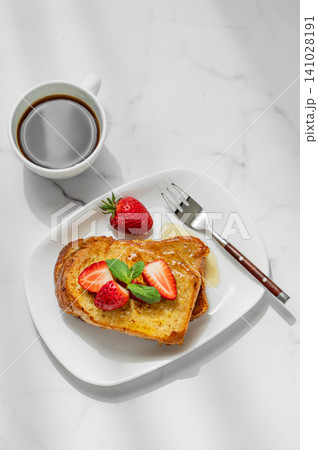 Brioche toasts with strawberry and honey on a plate on a marble background Brioche toasts with strawberry and honey on a plate on a marble background 141028191