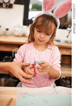 Little girl, bunny ears and cutting with scissors for arts and crafts, class project or decor. Closeup of child or kid with pattern, outline or paper shape in artwork for easter holiday at school Little girl, bunny ears and cutting with scissors for arts and crafts, class project or decor. Closeup of child or kid with pattern, outline or paper shape in artwork for easter holiday at school 141028217