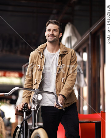 City, commute and happy man with bicycle walking on sidewalk, smile and eco friendly transport. Carbon neutral, sustainability and tourist on urban journey, morning travel or male with bike on street City, commute and happy man with bicycle walking on sidewalk, smile and eco friendly transport. Carbon neutral, sustainability and tourist on urban journey, morning travel or male with bike on street 141028236