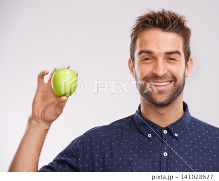 Studio, smile and portrait of man with apple for nutrition, healthy diet and weight loss. Green fruit, organic food and man with happiness for detox, self care and vitamin c on white background 141028627