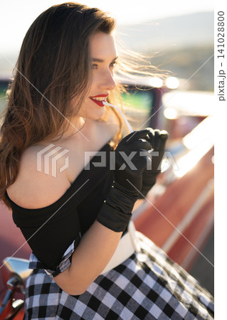 beautiful girl in retro style posing near vintage red cabriolet car. beautiful girl in retro style posing near vintage red cabriolet car. 141028800