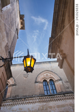Vintage street lamp against the historic Neo-Gothic facade of Palazzo Santa Sofia in Mdina 141028838
