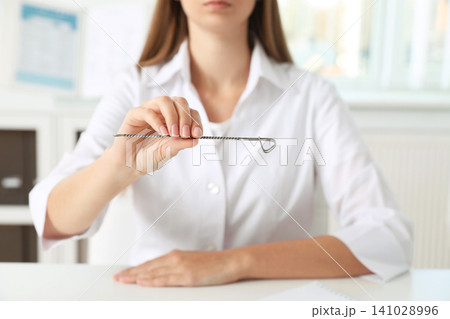 Speech therapist with logopedic probe in clinic, closeup 141028996