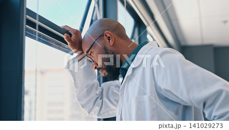 Doctor, healthcare and thinking at window of hospital with depression, medical decision and burnout. Medicine, african man and thoughtful professional in clinic with mental health, stress and anxiety Doctor, healthcare and thinking at window of hospital with depression, medical decision and burnout. Medicine, african man and thoughtful professional in clinic with mental health, stress and anxiety 141029273