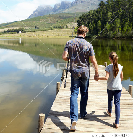 Father, daughter and holding hands by lake for fishing, vacation or summer with walk on jetty. Dad, man and girl child with bonding, connection and outdoor for adventure, learning or holiday by river Father, daughter and holding hands by lake for fishing, vacation or summer with walk on jetty. Dad, man and girl child with bonding, connection and outdoor for adventure, learning or holiday by river 141029370
