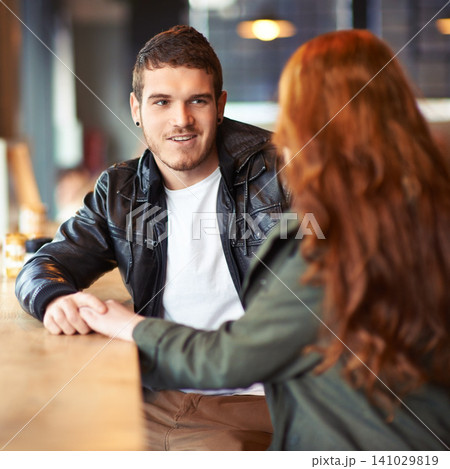 Couple, hand holding and conversation in restaurant, romance and affection on date. Valentines day, sitting together with love for bonding, female person with boyfriend for trust and compassion Couple, hand holding and conversation in restaurant, romance and affection on date. Valentines day, sitting together with love for bonding, female person with boyfriend for trust and compassion 141029819