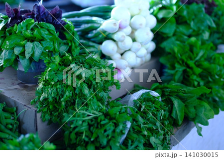 Fresh arugula parsley lettuce and mixed leafy greens displayed at farmers market with seasonal garden herbs and natural local harvest Fresh arugula parsley lettuce and mixed leafy greens displayed at farmers market with seasonal garden herbs and natural local harvest 141030015