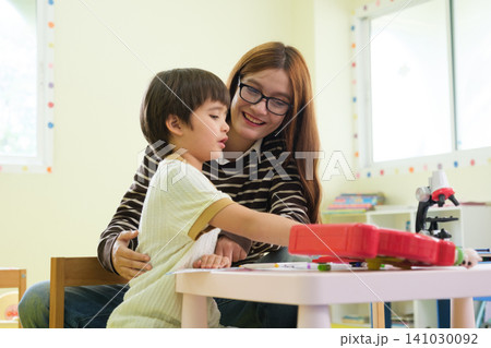The teacher is teaching young children in a class at school. The teacher is teaching young children in a class at school. 141030092