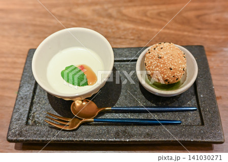 黒い石皿に美しく盛り付けられた高級中華コース料理のアミューズと胡麻菓子 141030271