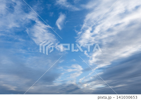 Beautiful blue sky filled with textured white clouds on a bright sunny day 141030653