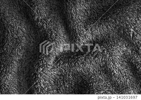 Crumpled fluffy black terry towel microfiber fabric texture with wrinkles and waves background Crumpled fluffy black terry towel microfiber fabric texture with wrinkles and waves background 141031697