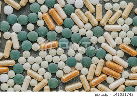 Full frame background pattern of various multi colored medical pills pharmaceutical tablets and gelatin supplement capsules mixed together on a surface Full frame background pattern of various multi colored medical pills pharmaceutical tablets and gelatin supplement capsules mixed together on a surface 141031742