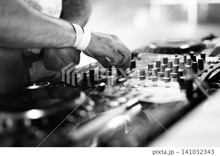 Black and white close-up of DJ hands mixing music on professional equipment Black and white close-up of DJ hands mixing music on professional equipment 141032343