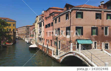 Panoramic view of a Venetian canal with a stone bridge and colourful historic buildings in Italy 141032446