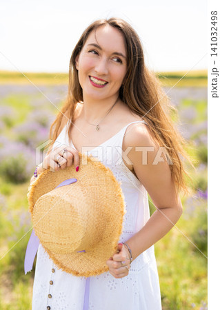beautiful girl in a dress with a straw hat on a lavender field beautiful girl in a dress with a straw hat on a lavender field 141032498