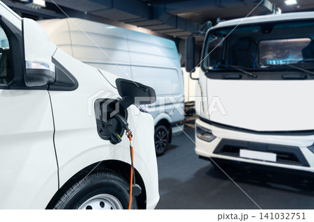 Close up of electric delivery van with connected charging cable Close up of electric delivery van with connected charging cable 141032751