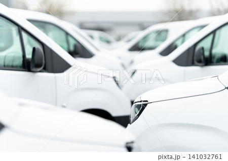 White delivery vans are parked in rows. Commercial fleet of vehicles White delivery vans are parked in rows. Commercial fleet of vehicles 141032761