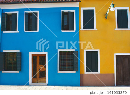 Row of iconic brightly coloured residential houses with shutters in Burano island, Venice, Italy Row of iconic brightly coloured residential houses with shutters in Burano island, Venice, Italy 141033270