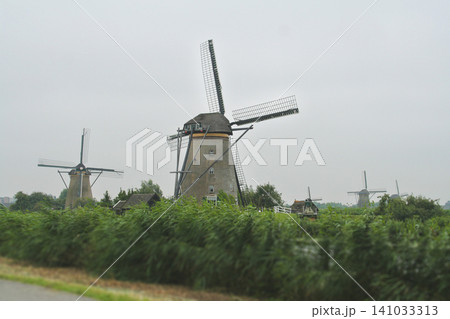 Historic windmills of Kinderdijk along a canal in the Netherlands Historic windmills of Kinderdijk along a canal in the Netherlands 141033313