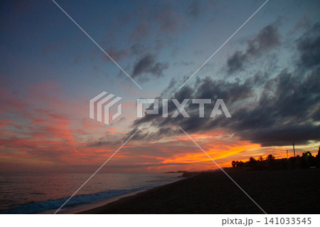 beautiful and colorful sunset, warm light and many clouds, sea waves on the sea coast beautiful and colorful sunset, warm light and many clouds, sea waves on the sea coast 141033545