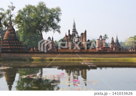 Ancient ruins of Wat Mahathat mirrored in water at Sukhothai Historical Park Thailand 141033626