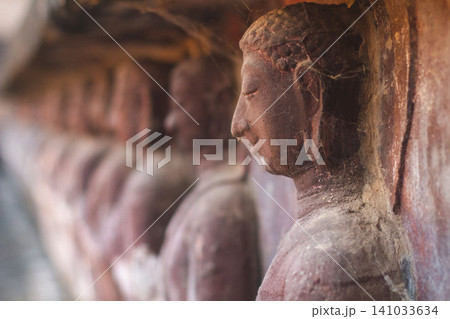 Row of ancient weathered Buddha statues in Wat Umong cave temple in Chiang Mai Row of ancient weathered Buddha statues in Wat Umong cave temple in Chiang Mai 141033634