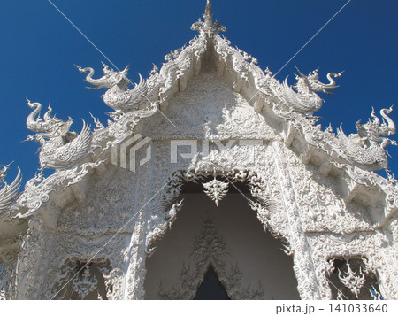 Ornate white pediment with mythical creatures at Wat Rong Khun White Temple in Chiang Rai Ornate white pediment with mythical creatures at Wat Rong Khun White Temple in Chiang Rai 141033640