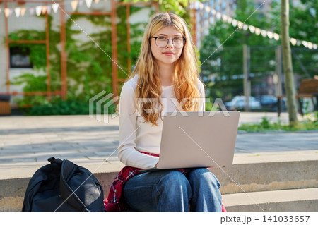 Happy teenage student with laptop on school campus 141033657