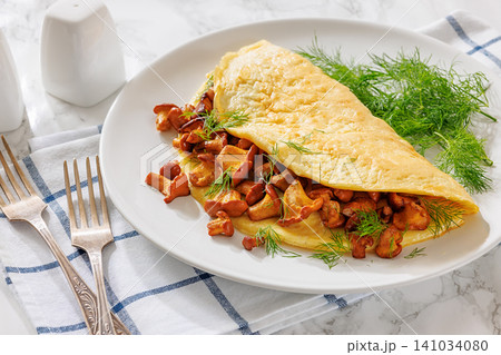 Egg omelet with fried wild chanterelles and dill 141034080