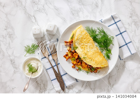 Egg omelet with fried wild chanterelles and dill 141034084