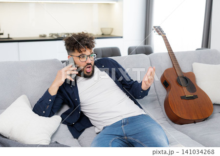 Young man receiving shocking news on phone call Young man receiving shocking news on phone call 141034268
