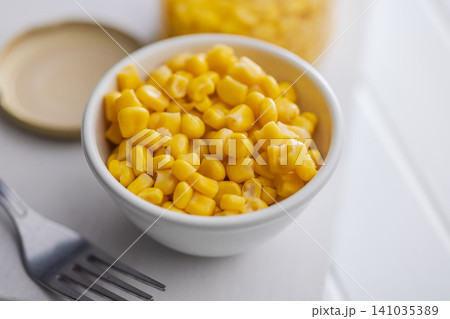 Close-Up Bowl Of Sweet Corn Kernels With Jar Of Corn In Soft Light Close-Up Bowl Of Sweet Corn Kernels With Jar Of Corn In Soft Light 141035389