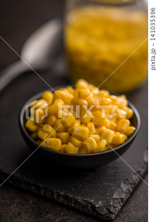 Close-Up Bowl Of Sweet Corn Kernels In Black Bowl On Dark Background Close-Up Bowl Of Sweet Corn Kernels In Black Bowl On Dark Background 141035396