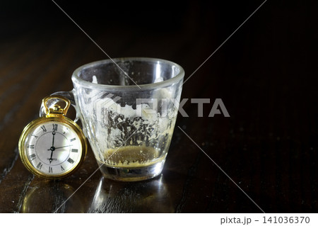 Empty espresso cup with vintage pocket watch 141036370