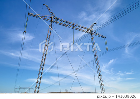 Steel pillar with high voltage electric power lines delivering electrical energy through cable wires on long distance 141039026