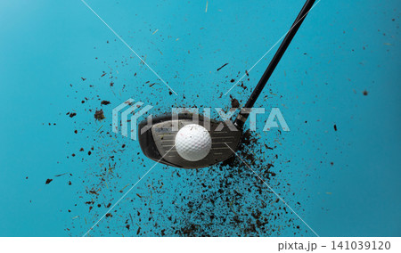 Golf ball explode from Tee off. Golfer hit ball with club to grass soil explosion on green. Golf club hit ball on green tee off with grass flying scatter. Blue sky background isolated Golf ball explode from Tee off. Golfer hit ball with club to grass soil explosion on green. Golf club hit ball on green tee off with grass flying scatter. Blue sky background isolated 141039120